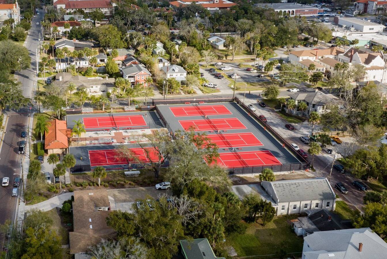 Vista aérea de una zona residencial con un amplio complejo de canchas de tenis.