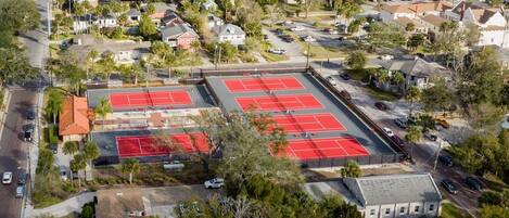 Vista aérea de una zona residencial con un amplio complejo de canchas de tenis.