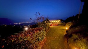 Une vue nocturne d’un chemin bien éclairé menant à un bâtiment doté d’un espace extérieur abrité.