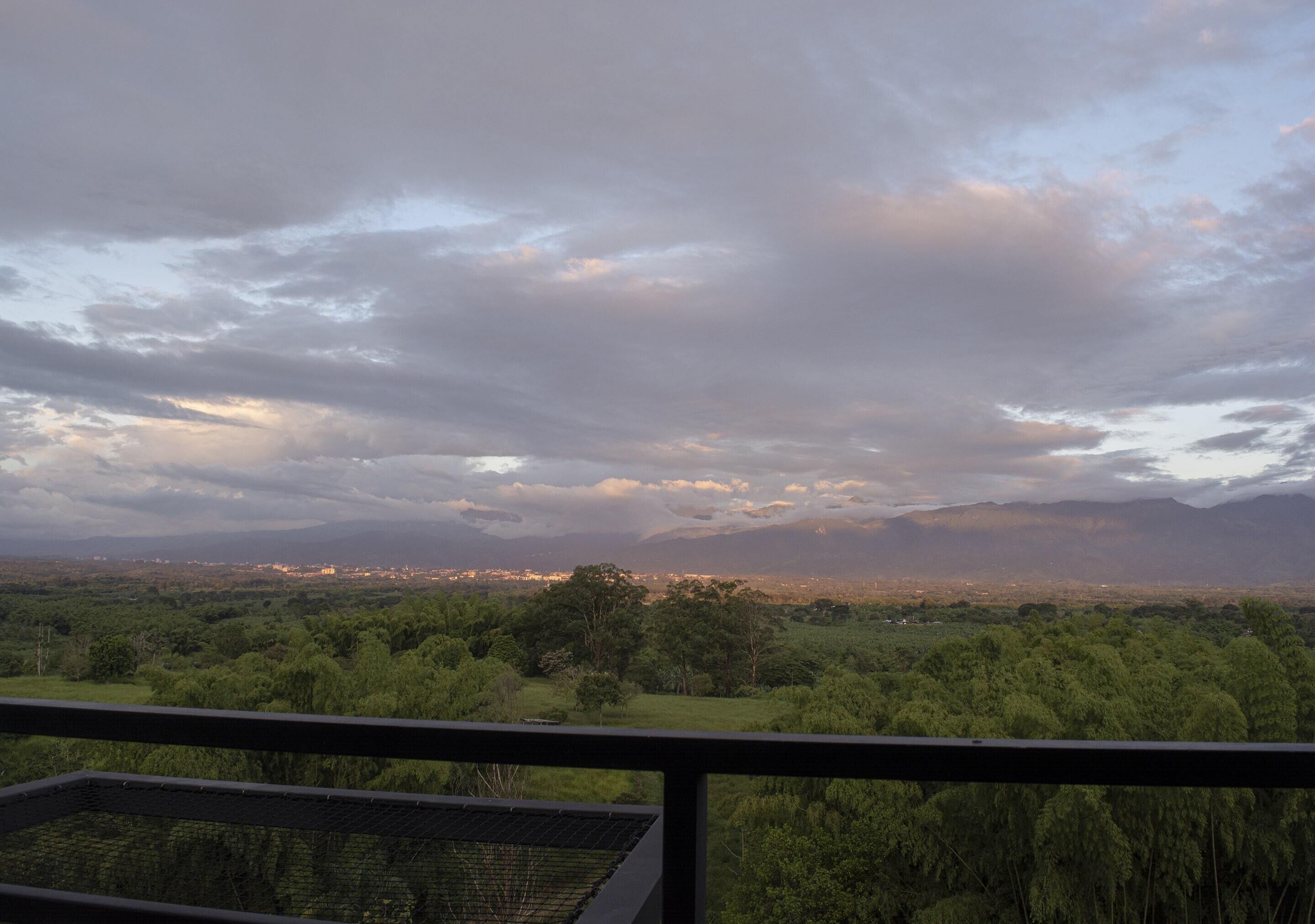 A balcony with a view of a cityscape and mountains in the distance.