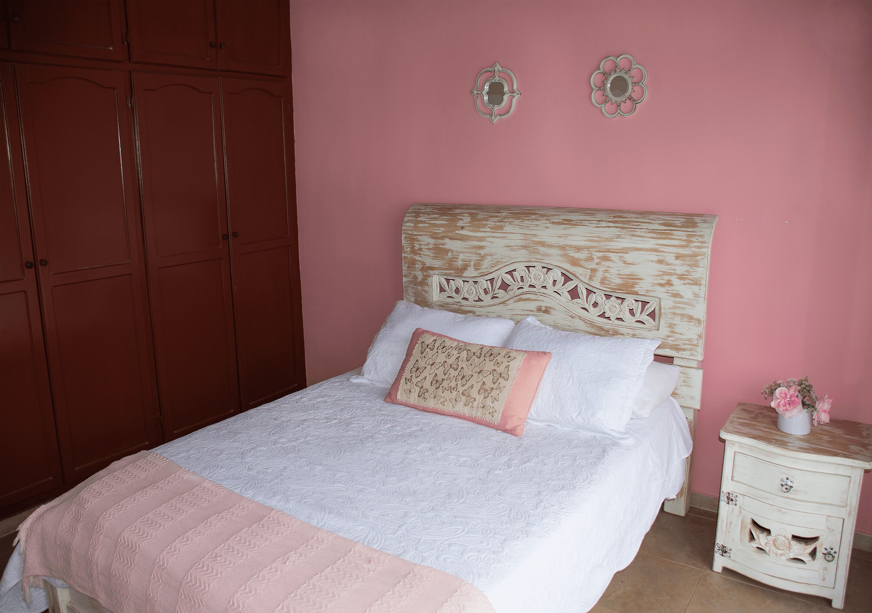 A bedroom with a bed, a nightstand, and a wardrobe.