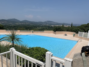 Une piscine avec vue sur les montagnes et la verdure.