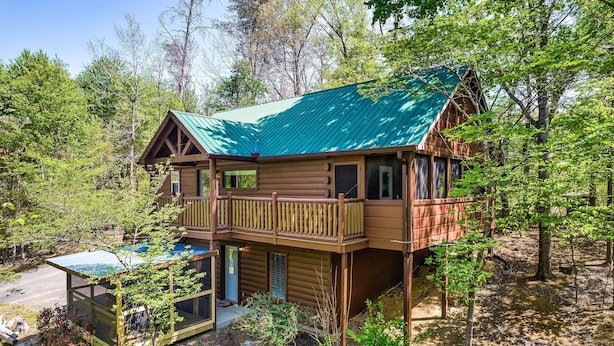 A two-story log cabin with a green metal roof, a balcony, and a glass enclosure. - Book Your 2026 Vacation!, Private!, Hot Tub, Great for Families, Sleeps 8! (Sevierville)