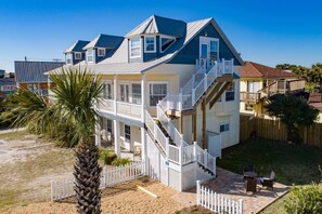 Une maison à deux étages avec un balcon, un escalier et une cour clôturée.