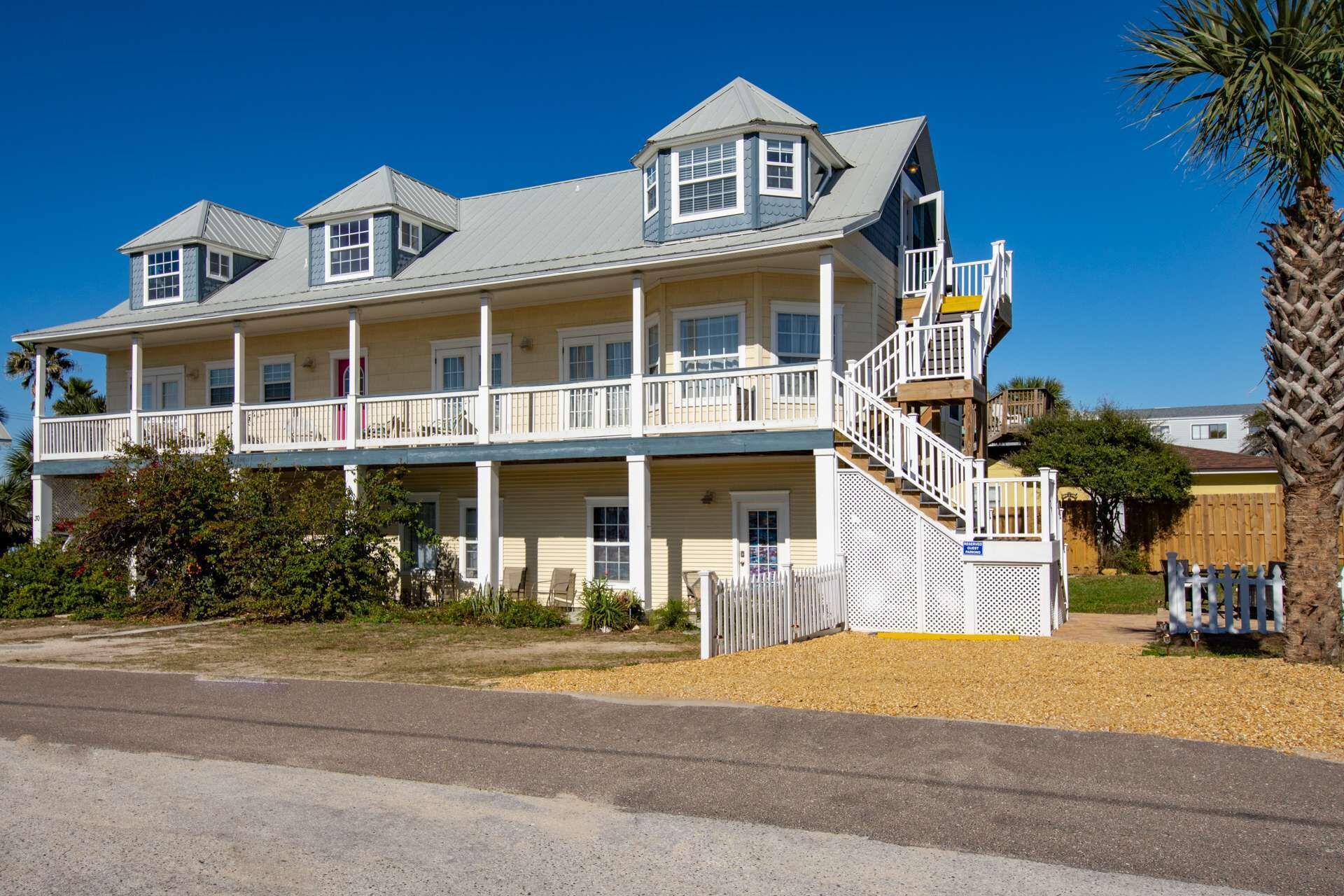 A two-story building with a balcony and a staircase leading to an upper level.