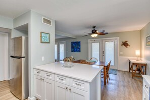 Enjoy cooking in this well-equipped kitchen with a central island, stainless steel appliances, and a dining area.