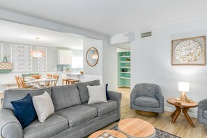 A modern living room with a grey sofa, a round wooden coffee table, and a grey armchair. - Seascape 1 (St. Augustine)