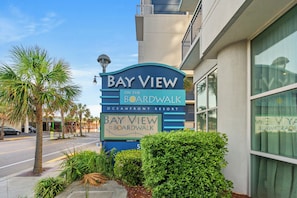 En skylt för Bay View, placerad vid strandpromenaden på Oceanfront Resort, som tydligt visar resortens namn och läge.