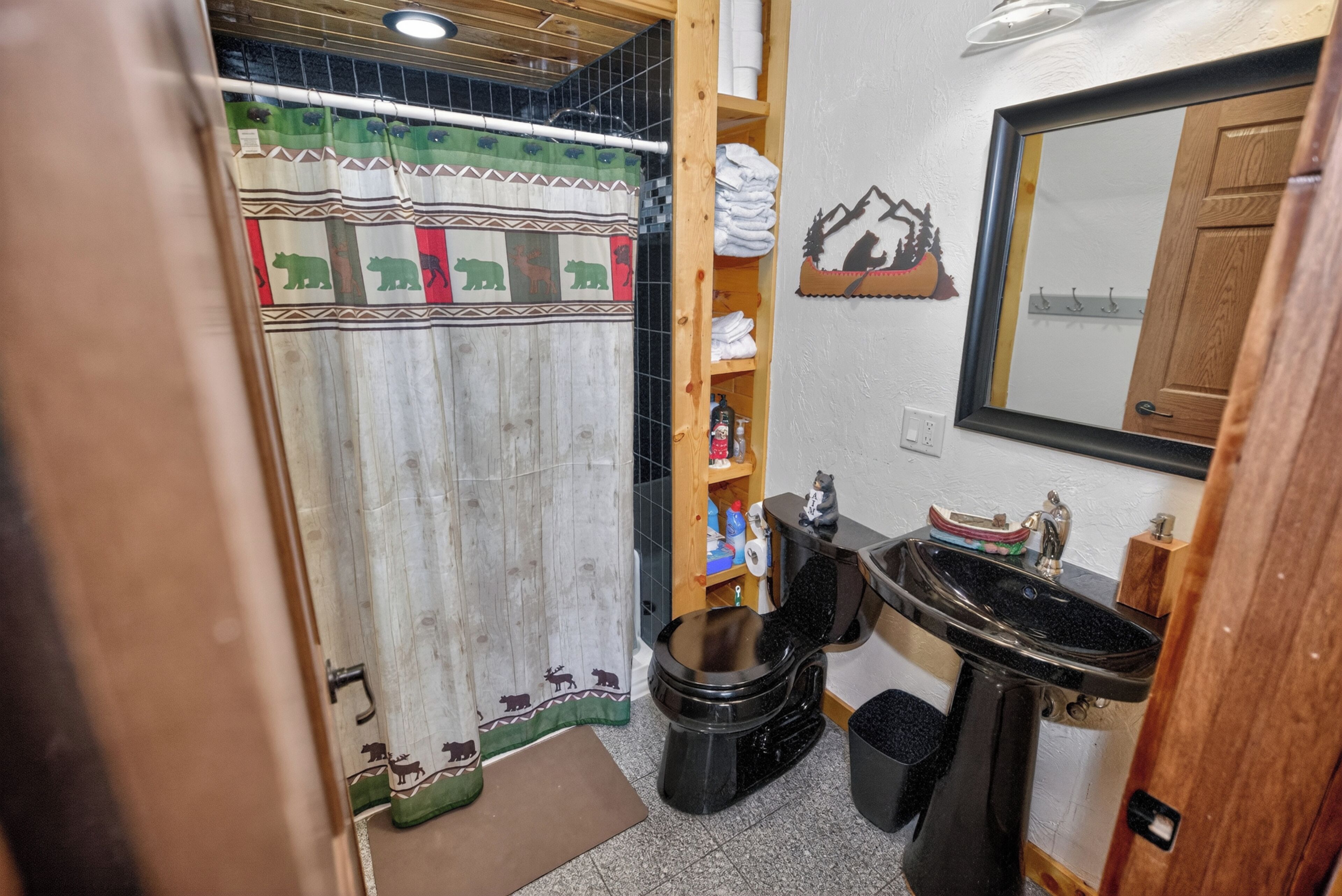 Un baño con cortina de ducha, inodoro, lavamanos y espejo.