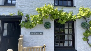 A building with a white exterior and black-framed windows, labeled "SAINT CLAIRE". - 4 Trenhaile Terrace (Truro)