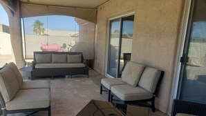 Un espace extérieur aménagé avec un canapé, des fauteuils et une table.