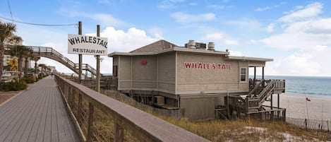 A beachside wooden structure labeled 'Whale's Tail' with a sign for 'Whale's Tail Restaurant' above it.