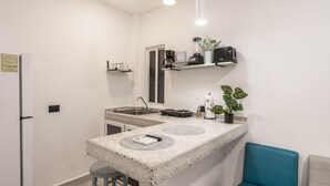 Una cocina compacta con encimera, un lavamanos y un pequeño comedor.