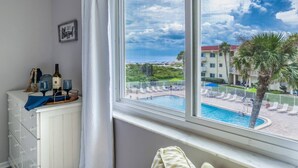 Une chambre avec vue sur une piscine et une plage.