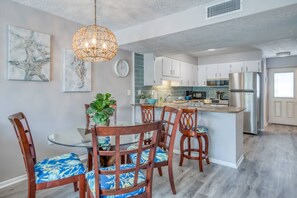 Enjoy meals in the kitchen with an island and sink, and dine at the glass table with comfortable seating.