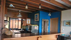 Uma cozinha com bancadas de madeira, geladeira e parede azul.