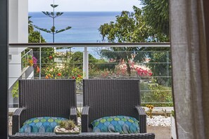 Two wicker chairs with patterned cushions on a balcony with a view of the sea and garden. - Near the Funchal centre - Barreiros II (Funchal)