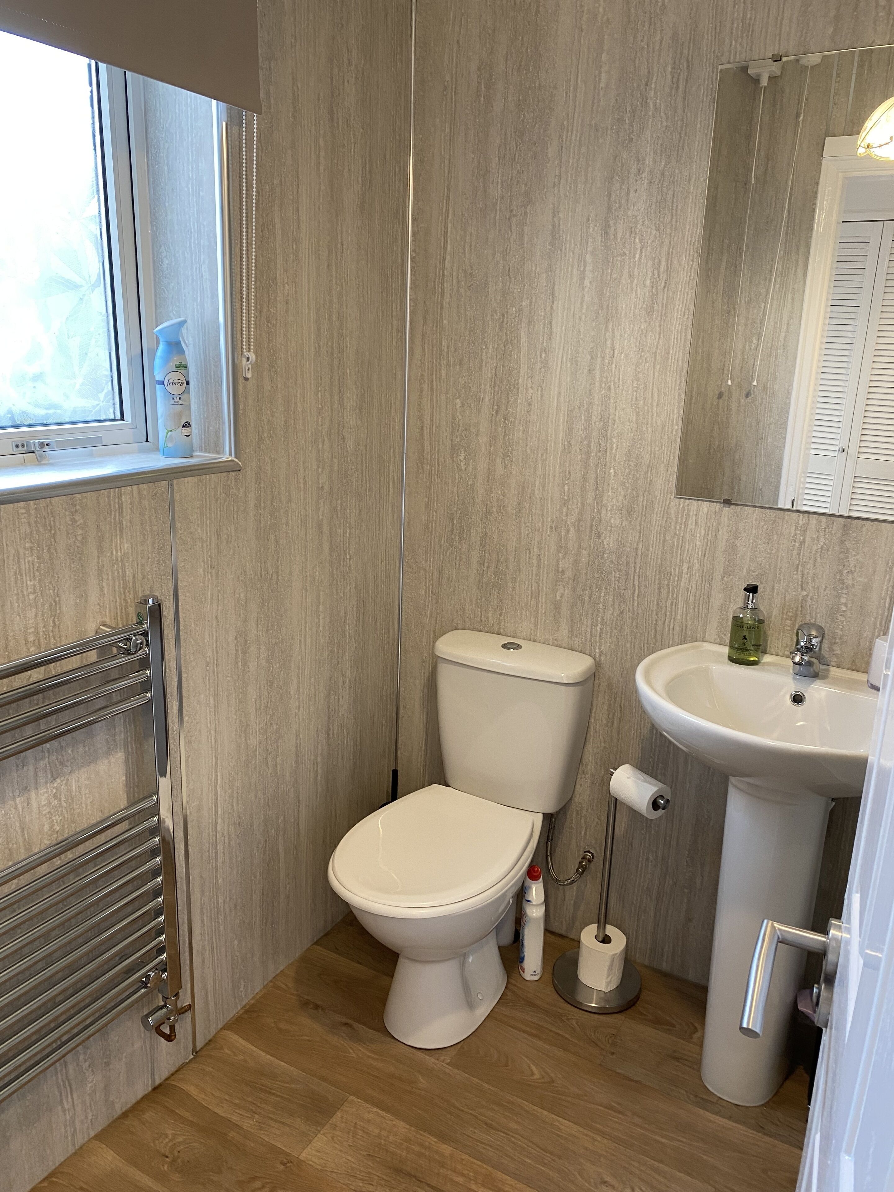 A bathroom with a toilet, sink, and towel rack.