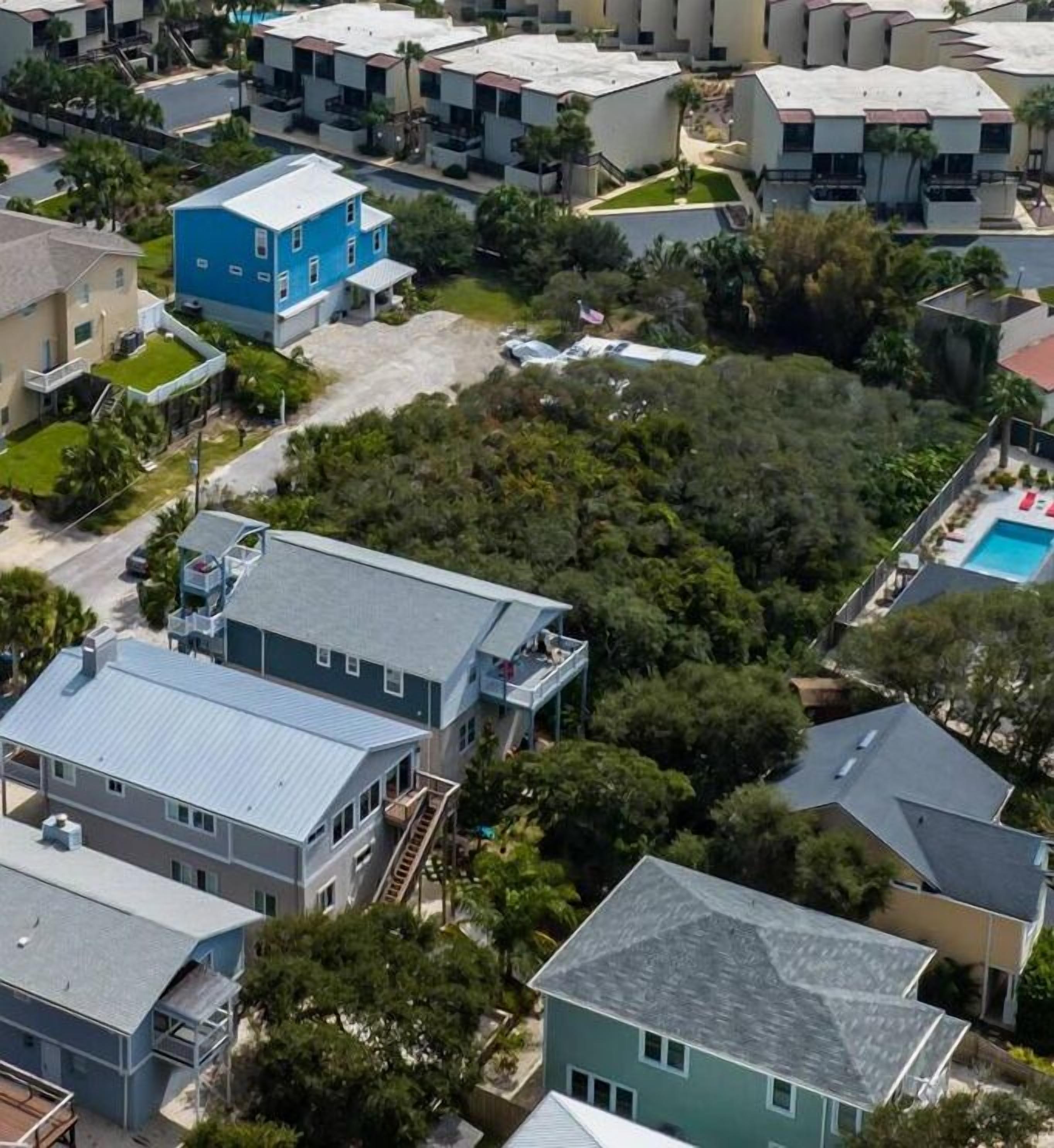 A residential area with modern houses, a swimming pool, and a green space.