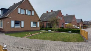 Un barrio residencial con casas de ladrillo, senderos pavimentados y un césped cuidado.