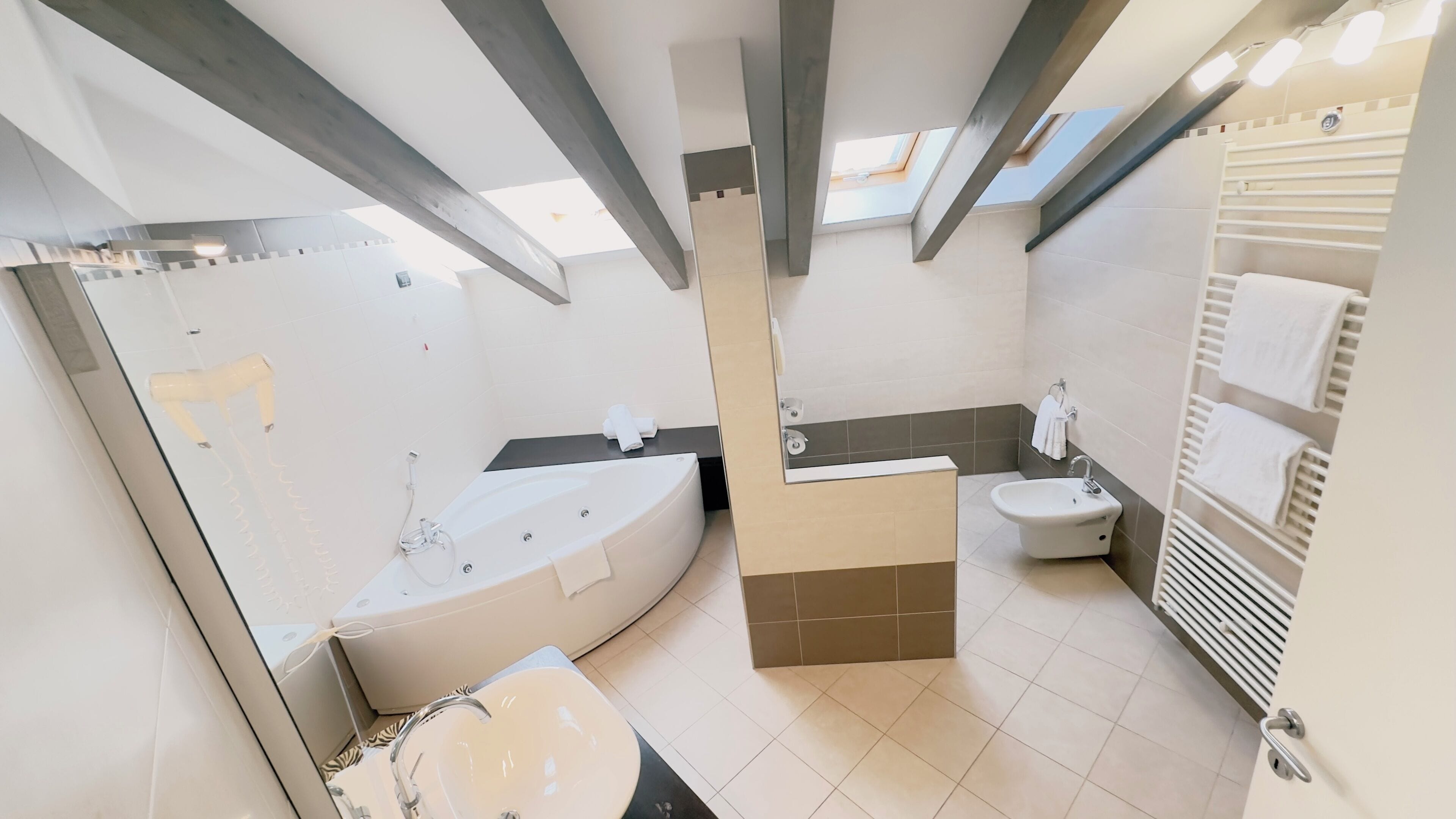 A modern bathroom with a bathtub, shower, and toilet.