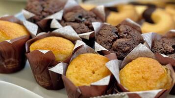 Variedad de pasteles en vasos de papel, como muffins y galletas.