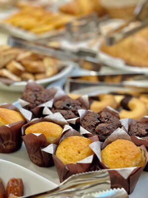 A variety of pastries in paper cups, including muffins and cookies. - Hotel Malpensa Inn (Lonate Pozzolo)