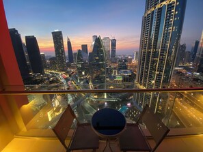 Blick auf eine Stadtlandschaft von einem Hochhaus mit moderner Architektur, inklusive einer Essecke mit rundem Tisch und Stühlen.