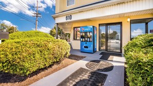 A building with a Pepsi vending machine outside, a number 610 sign, and a well-maintained hedge. - Red Carpet Inn Edison (Edison)