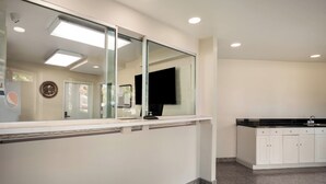 A modern kitchen with a large island, white cabinetry, and a black countertop. - Red Carpet Inn Edison (Edison)