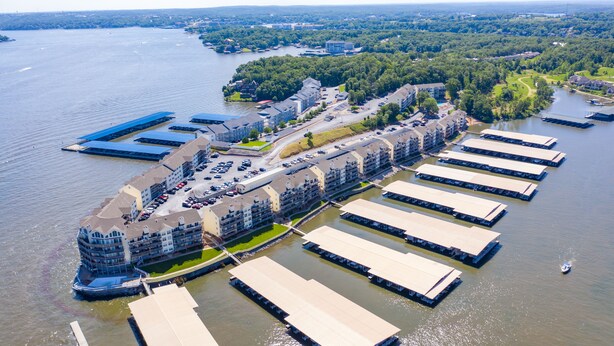 Ein Luftbild eines Hotels am Wasser mit mehreren Gebäuden, einer Marina und einem großen Parkplatz.