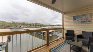 Ein Balkon mit Blick auf einen Yachthafen, angestellte Boote und ein Strandschild.