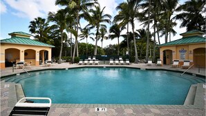 Una piscina con tumbonas y palmeras.