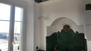 A room with a large window, a green tiled wall, and a decorative ceiling. - Apartment (nice)