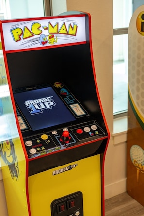 A Pac-Man arcade machine with a yellow and red color scheme, featuring a joystick, buttons, and a screen displaying the game title.