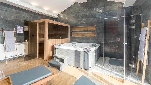 A modern bathroom with a glass-enclosed shower, a wooden sauna, and a large bathtub. - Oasis of peace, with wellness, playground, pool, barbecue (Mofardini)