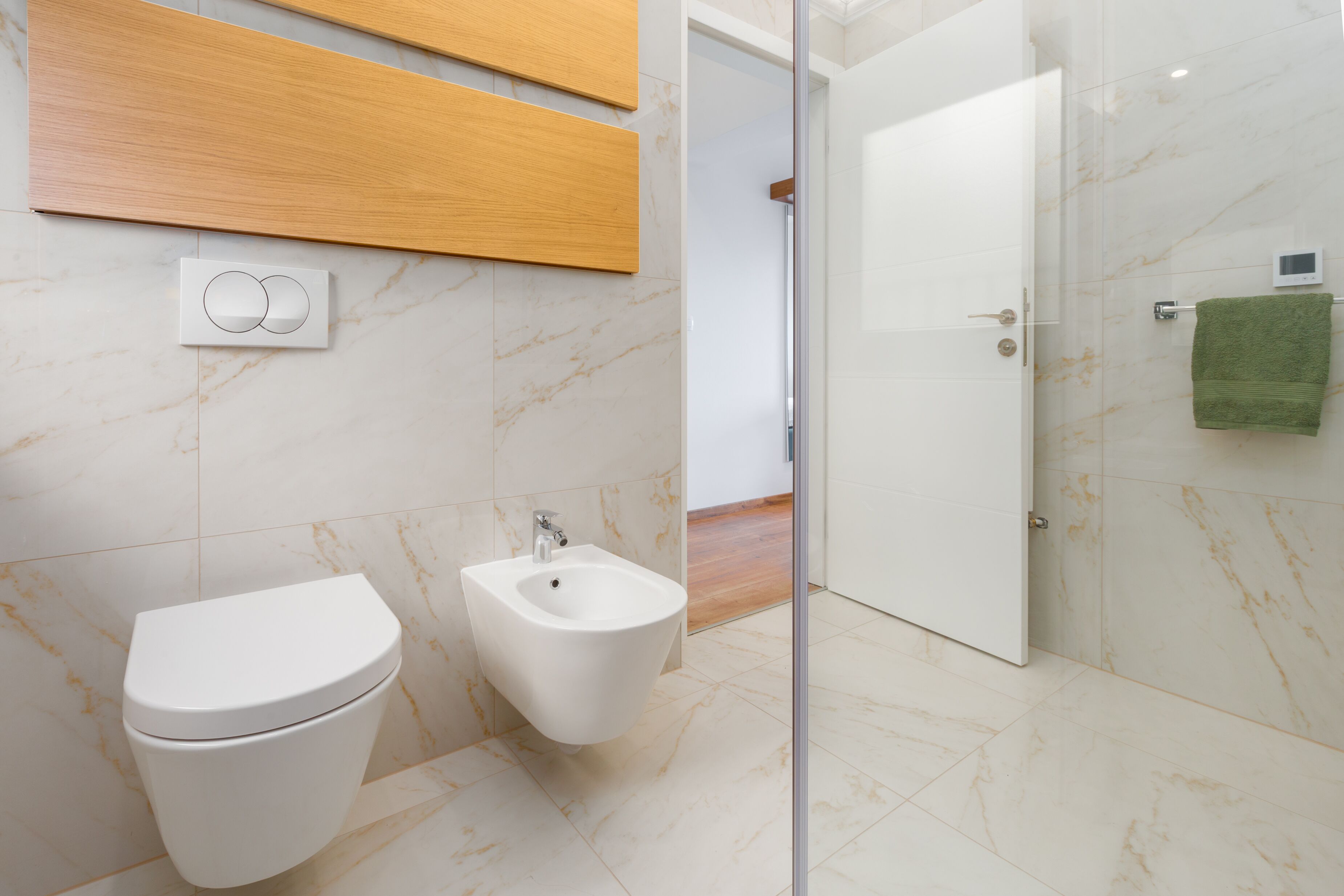 Ein modernes Badezimmer mit Toilette, Bidet und Duschbereich.