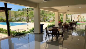 Un espace extérieur aménagé avec une piscine, des tables et des chaises.
