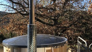 A hot tub with a metal exterior and wooden steps, surrounded by trees and a clear sky. - Loft at the foot of the Ventoux with swimming pool, jacuzzi and balneotherapy. (Mollans-sur-Ouvèze)