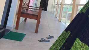Un espacio al aire libre techado con techo de madera, un banco y una puerta.