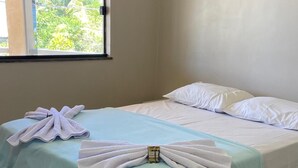 Habitación de hotel con cama, ventana y vista a zonas verdes.