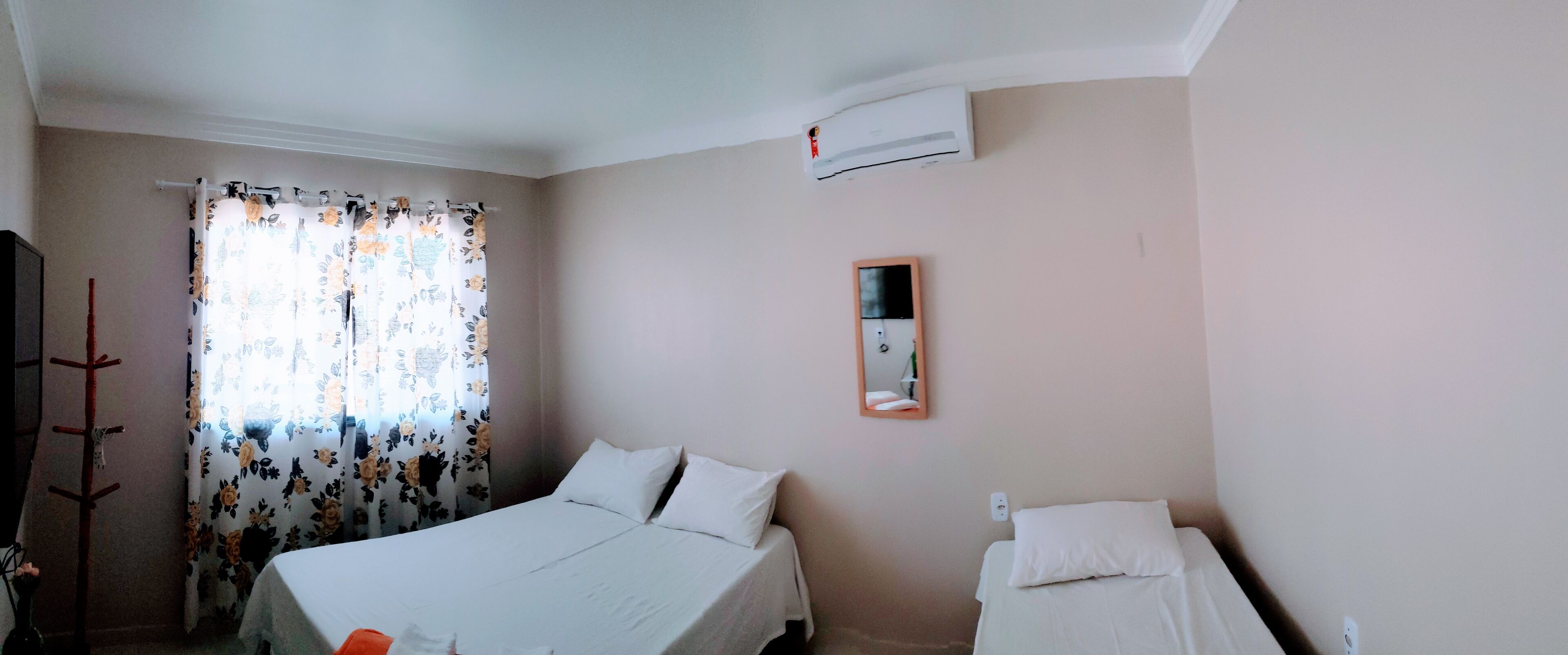 Una camera da letto con un letto, un comodino, uno specchio e un condizionatore d'aria.