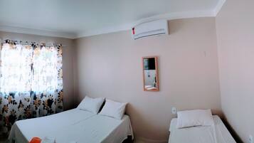 Una camera da letto con un letto, un comodino, uno specchio e un condizionatore d'aria.