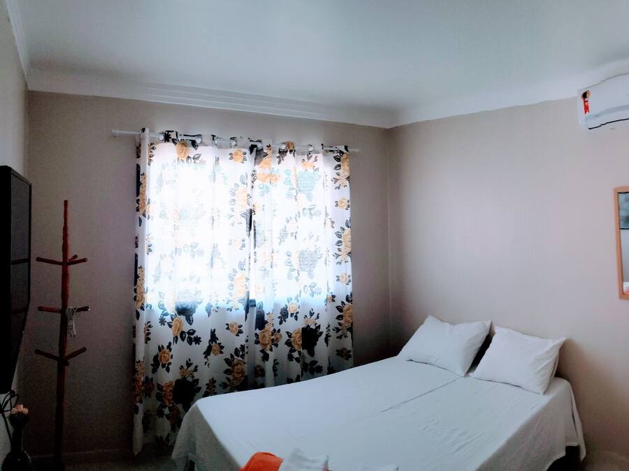 Una camera da letto con un letto, un comodino, uno specchio e un condizionatore d'aria.