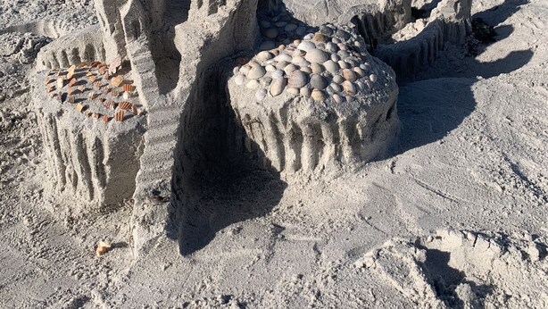 A sandcastle on a beach with a clear view of the ocean in the background. - Sunset Beach Condo (Treasure Island)