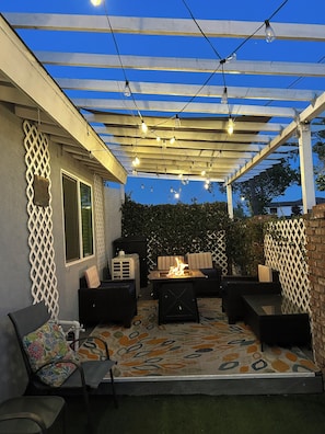 An outdoor patio with a pergola, string lights, a fire pit, and outdoor furniture. - Modern Residence in Torrance 15 mins from LAX (Torrance)