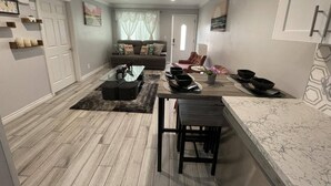 Un salon moderne comprenant un canapé, une table basse et une table à manger avec des chaises.