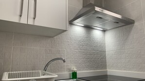 Een moderne keuken met witte kasten, een RVS spoelbak en een zwart aanrecht.