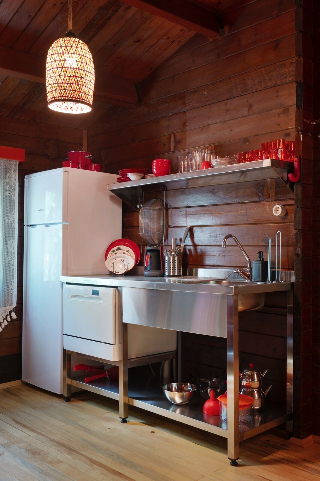 Eine kleine Küche mit Kühlschrank, Spüle und diversen Küchenutensilien.