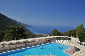 A pool with lounge chairs and a view of the sea. - Nicholas Park Hotel (Fethiye)